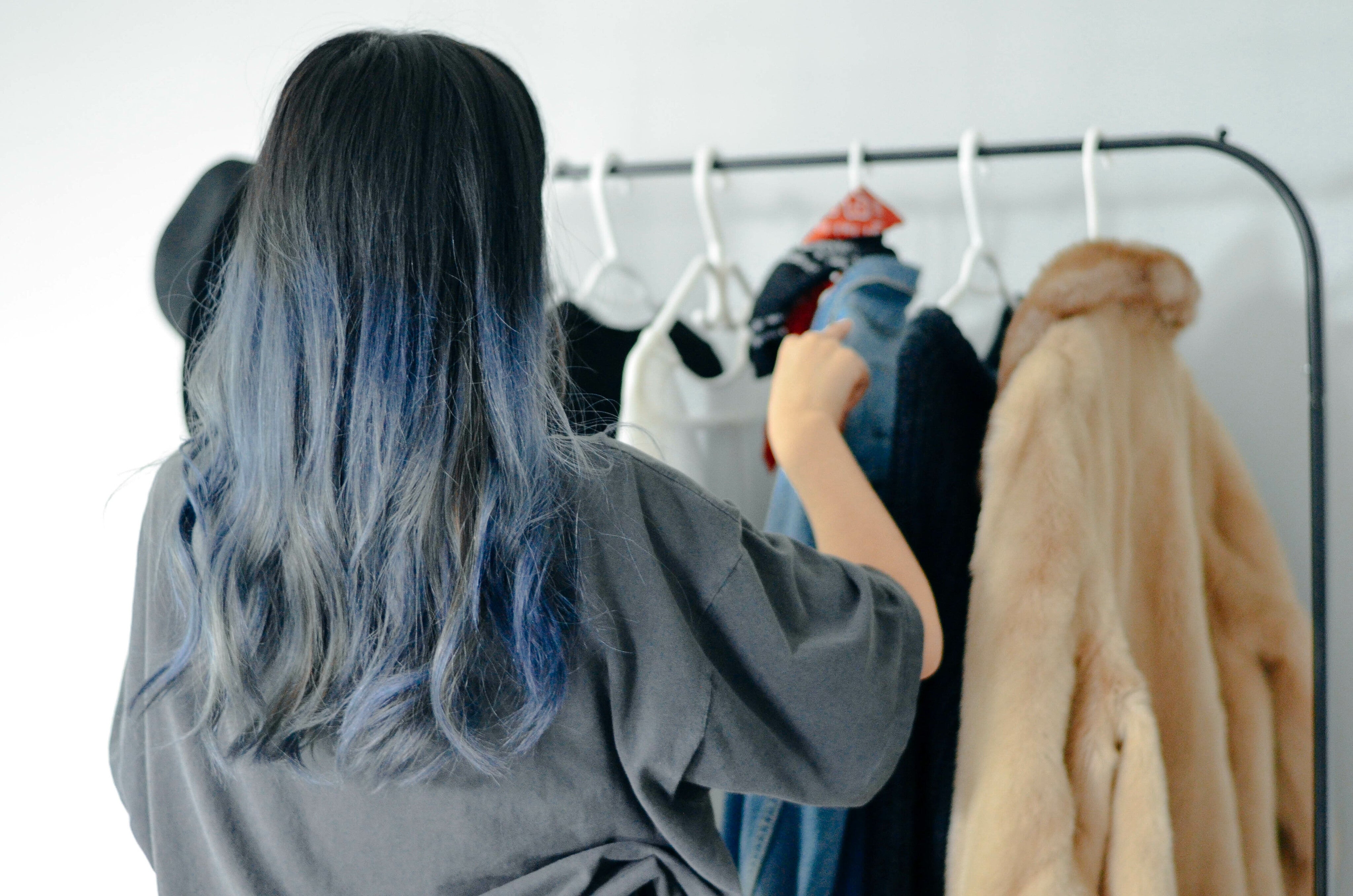person-organizes-clothes-on-a-thin-clothing-rack.jpg